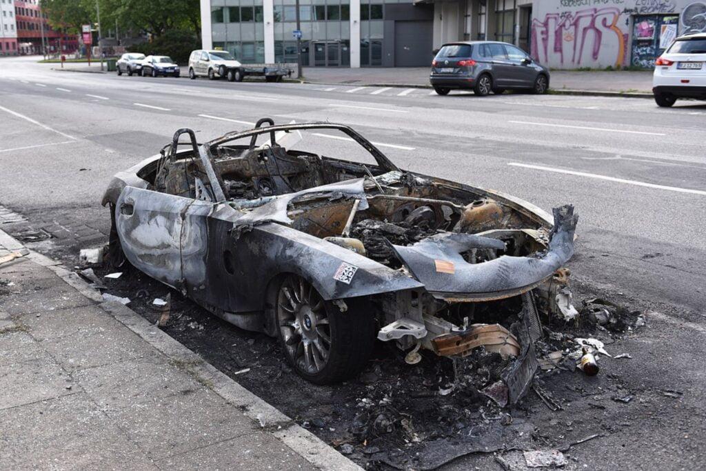 A burnt BMW car after the first night of riots,